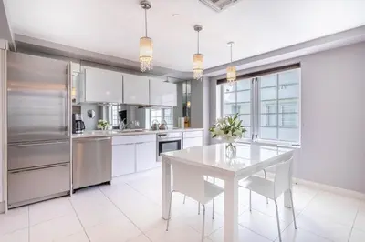 a kitchen with a white table and white appliances at Luxury Large 1BR at The Carlyle SoBe Sleeps 4 in Miami Beach