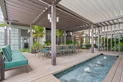 a patio with a table and chairs and a swimming pool at NEW Luxury Bay View Downtown 1 Bedroom in Miami