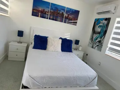 a bedroom with a white bed with blue pillows at Villa Clara Blue-Little Havana in Miami