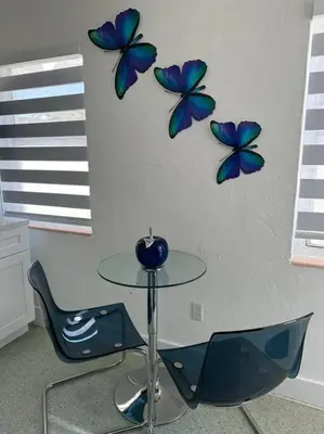 a table and a chair with blue butterflies on a wall at Villa Clara Blue-Little Havana in Miami