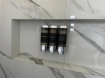 a glass shelf with four bottles on it at Villa Clara Blue-Little Havana in Miami