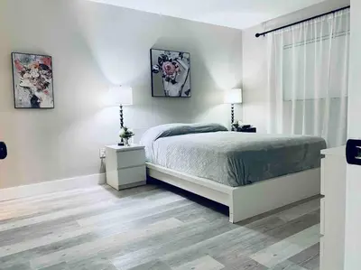 a white bedroom with a bed and a window at Modern 1BR 1BA Condo 1Block to Aventura Mall in Aventura