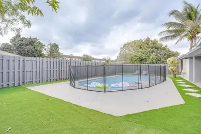 a swimming pool in a yard with a fence at Oasis of Sunrise in Sunrise