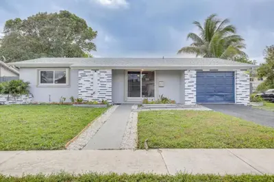 a white house with a blue garage at Oasis of Sunrise in Sunrise