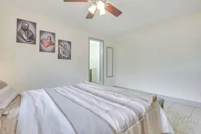 a white bedroom with a bed and a ceiling fan at Oasis of Sunrise in Sunrise