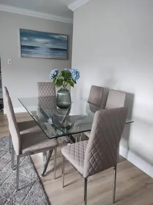 a glass dining room table with chairs and a vase with flowers at Amazing Deal! Dania Beach Home with Pool & Jacuzzi in Dania Beach