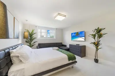 a bedroom with a large bed and a couch at Sunny Isles Beachfront Oasis, Modern & Spacious in Sunny Isles Beach