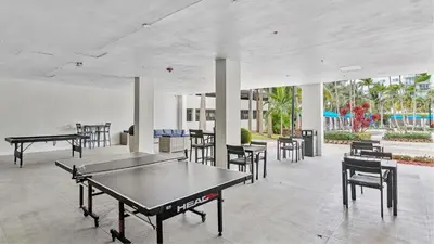 a room with ping pong tables and chairs at Sunny Isles Beachfront Oasis, Modern & Spacious in Sunny Isles Beach