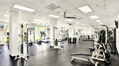 a gym with several treadmills and machines in it at Sunny Isles Beachfront Oasis, Modern & Spacious in Sunny Isles Beach