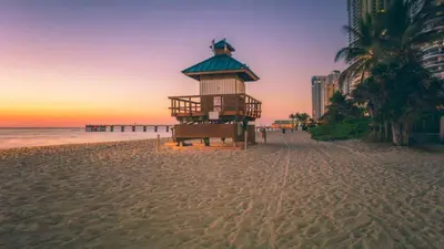 a lifeguard tower on the beach at sunset at Sunny Isles Beachfront Oasis, Modern & Spacious in Sunny Isles Beach