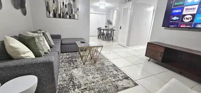 a living room with a couch and a table at Big TV 2 Bedroom Apartment Cooper City in Cooper City