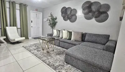 a living room with a couch and a table at Big TV 2 Bedroom Apartment Cooper City in Cooper City