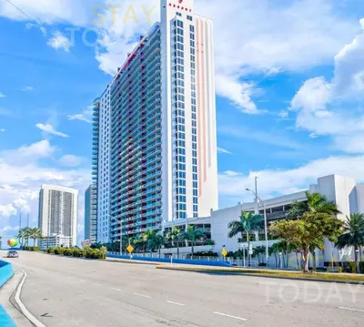 a tall building on the side of a road at Escape to Beachwalk Resort in Chic Apartment in Hallandale Beach