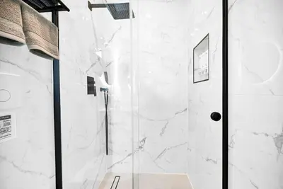 a shower with a glass door in a bathroom at Modern Oasis Near Design District, Wynwood in Miami