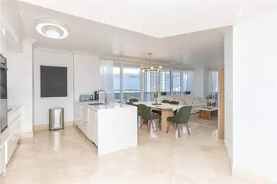 a kitchen and living room with a table and chairs at Elegant Resort - Beautiful Views in Hallandale Beach