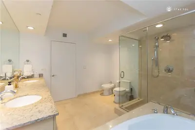 a bathroom with two sinks and a shower and a toilet at Elegant Resort - Beautiful Views in Hallandale Beach