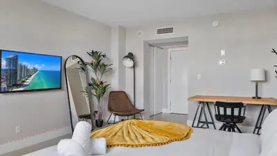 a bedroom with a bed and a tv on a wall at Absolute Beach Bliss, Chic & Expansive Retreat in Sunny Isles Beach