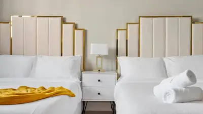 two beds with white sheets and a teddy bear on them at Absolute Beach Bliss, Chic & Expansive Retreat in Sunny Isles Beach