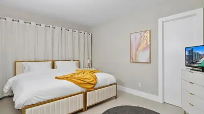 a bedroom with a bed with a yellow blanket on it at Absolute Beach Bliss, Chic & Expansive Retreat in Sunny Isles Beach