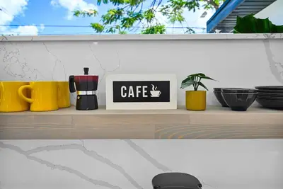 a shelf with coffee cups and a clock on it at Modern Studio Near Design District, Wynwood in Miami