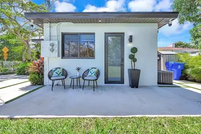 a white house with two chairs and a table at Modern Studio Near Design District, Wynwood in Miami