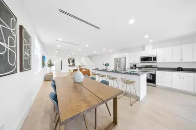 a large white kitchen with a wooden table and chairs at Up to 12 guests! Modern Villa near Wynwood 29! in Miami