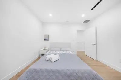 a white bedroom with a large bed and white walls at Up to 12 guests! Modern Villa near Wynwood 29! in Miami