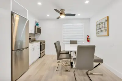 a kitchen with a table and chairs and a refrigerator at ULTRA peaceful 2 bedroom beach&boardwalk apartment in Hollywood