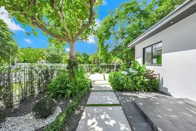 a garden with a tree and a fence at Stylish Oasis in Design District, Near Wynwood in Miami