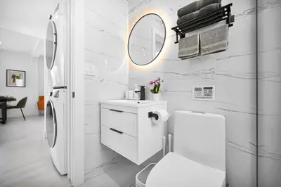 a bathroom with a toilet and a sink and a mirror at Stylish Oasis in Design District, Near Wynwood in Miami