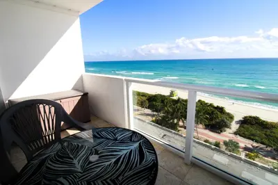 a balcony with a chair and a view of the ocean at Castle 830 OceanView Balcony Studio, Pool, Tennis, Free Parking in Miami Beach