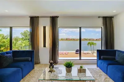 a living room with blue couches and a large window at Club House 305 w PRIVATE NIGHTCLUB, Cinema, Game Room, Gym & Pool in Miami