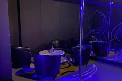 a room with chairs and a table with purple lights at Club House 305 w PRIVATE NIGHTCLUB, Cinema, Game Room, Gym & Pool in Miami