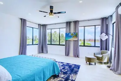 a bedroom with a blue bed and windows at Club House 305 w PRIVATE NIGHTCLUB, Cinema, Game Room, Gym & Pool in Miami