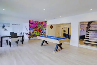 a room with a ping pong table and a dining room at Club House 305 w PRIVATE NIGHTCLUB, Cinema, Game Room, Gym & Pool in Miami