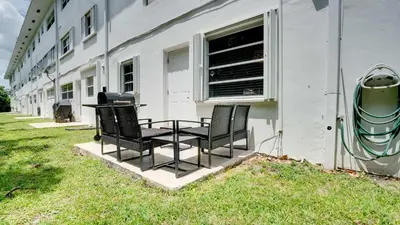 two chairs sitting next to a building with a grill at Serene 1BR Haven Fort Lauderdale in Fort Lauderdale