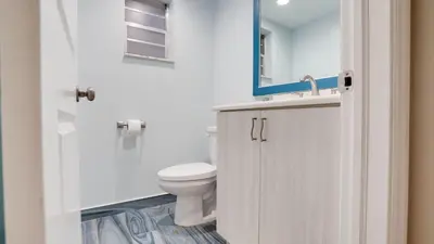 a bathroom with a toilet and a sink and a mirror at Serene 1BR Haven Fort Lauderdale in Fort Lauderdale