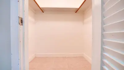 a walk in closet with white walls and a tile floor at Serene 1BR Haven Fort Lauderdale in Fort Lauderdale