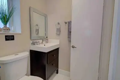 a bathroom with a sink and a toilet and a mirror at The Palms Villa with Cinema, Game Table, Pool, Jacuzzi , Giant Chess, 8 Beds in Miami