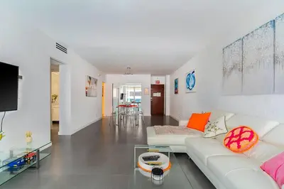 a living room with a white couch and a glass table at Welcome to our beach home! in Hollywood