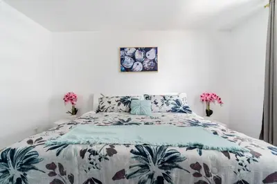 a bedroom with a bed with a floral bedspread at Welcome to our beach home! in Hollywood