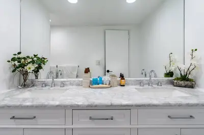 a white bathroom with two sinks and a large mirror at Welcome to our beach home! in Hollywood
