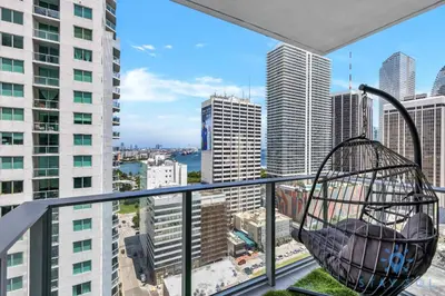 a swing on a balcony with a view of a city at Beautiful Apartment with gym and amazing Pool in Miami