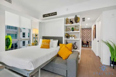 a bedroom with a large bed and yellow pillows at Beautiful Apartment with gym and amazing Pool in Miami