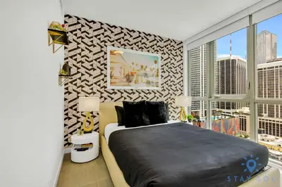 a bedroom with a large bed and a window at Beautiful Apartment with gym and amazing Pool in Miami