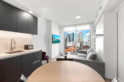a kitchen and living room with a couch and a table at Luxury One-Bedroom w Top Amenities! in Miami