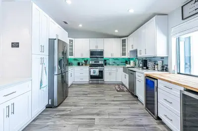 a large white kitchen with white cabinets and appliances at Miami amazing location, Luxury & Spacious, Large pool, BBQ, Game room, Pool in Miami