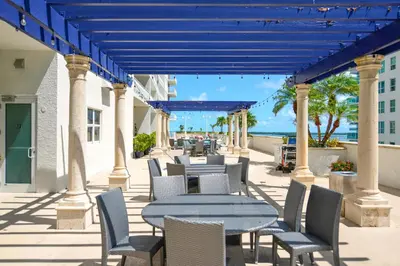 a patio with tables and chairs with the ocean in the background at Beautiful Condo w Breathtaking Views! in Miami