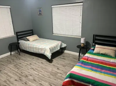 a bedroom with two beds and two windows at 5 Minutes to Ocean & Casino's - Large Backyard in Hollywood