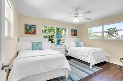 a bedroom with two beds and a ceiling fan at Steps to Beach, Pool, Backyard Oasis, Game Room in Fort Lauderdale
